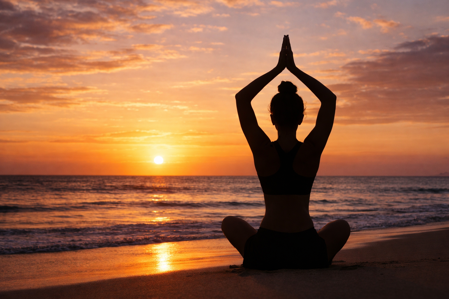 Person doing yoga at sunset on beach, silhouette